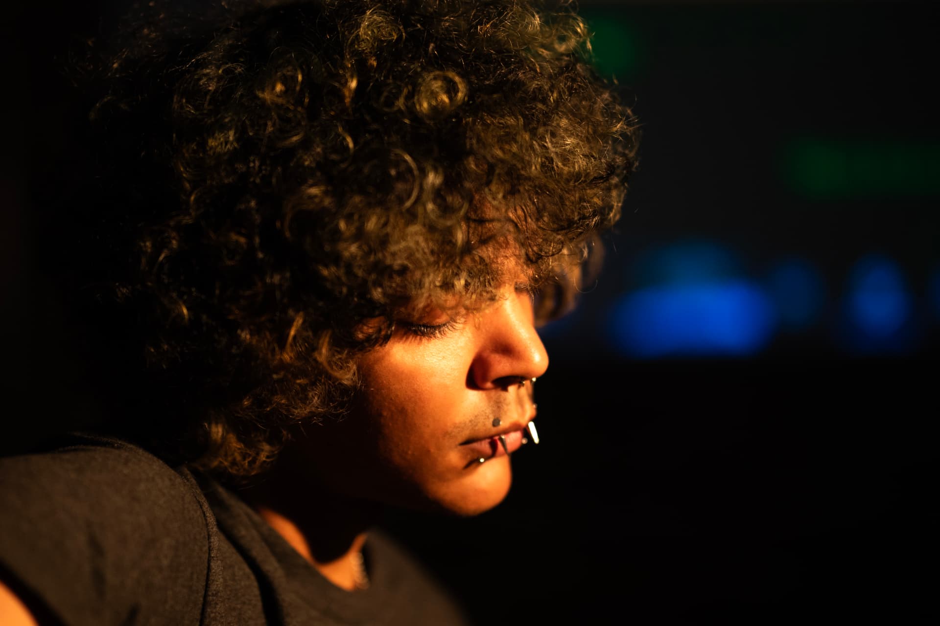Close-up stage portrait in warm light against dark backdrop